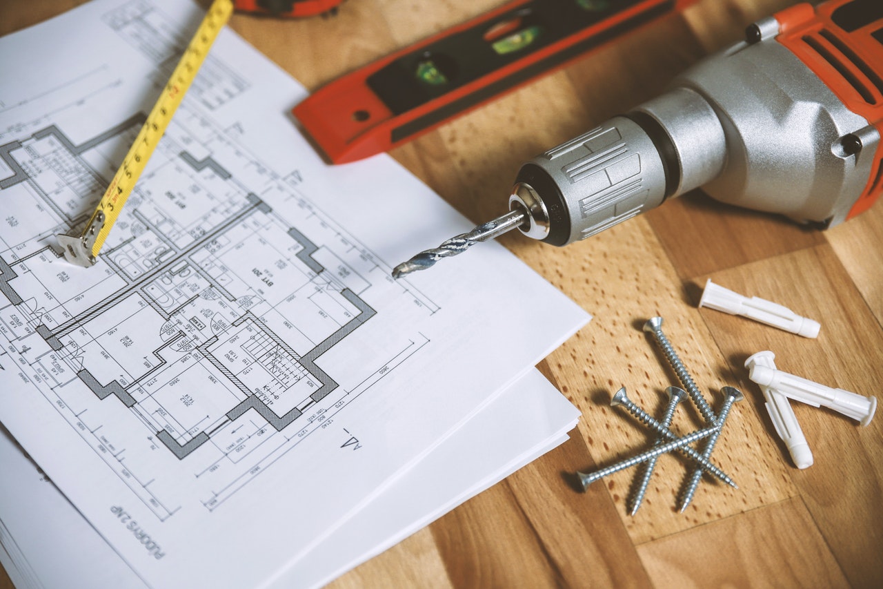 Floorplan and tools on wooden surface
